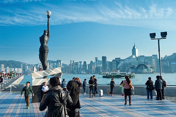 Hong Kong, China - January 29, 2013: Travelers visiting the Tsim Sha Tsui Promenade (Avenue of the Stars) on Jan 29, 2013 in Hong Kong. The Avenue of Stars is located along the Victoria Harbor in Hong Kong.